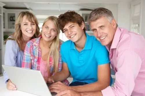 smiling family using laptop